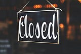 Sign on glass door that says closed