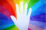 Photo of a radiant color wheel with a hand waving in the middle.