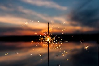 A sparkler with a sunset background.