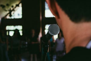 A man is talking on stage to an audience.