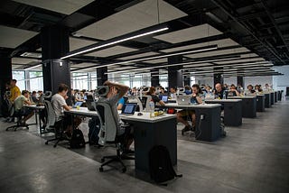 Office setting: rows of workers sitting staring at computer screens