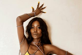 Beautiful and shapely, brown-skinned Black woman in yellow bikini posed seductively
