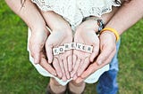 Couple holding Scrabble tiles that spell FOREVER in their hands