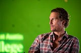 Matthew McConaughey in front of a green backdrop.