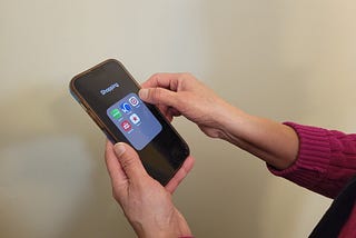 Hands holding a smartphone with shopping apps displayed on screen