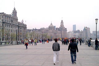Image shows Shanghai in 2012, with people promenading along the Bund. (Photo copyright © 2024 by John Peyton Cooke)
