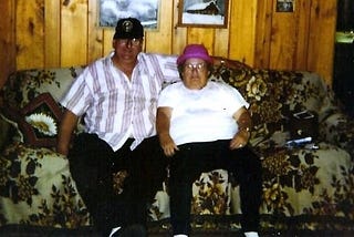 An image showing the author’s parents, Dale and Vivian sitting together on a couch in a hunting cabin