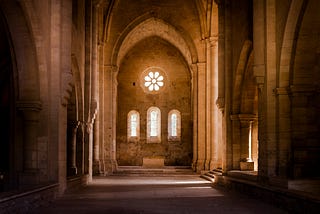 Sunlight shining through windows in an empty chapel.