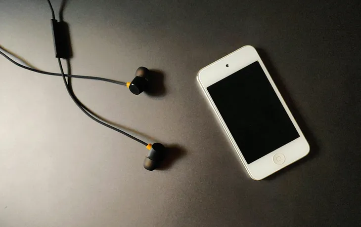 Photo image of an iPod with a pair of wired headphones.