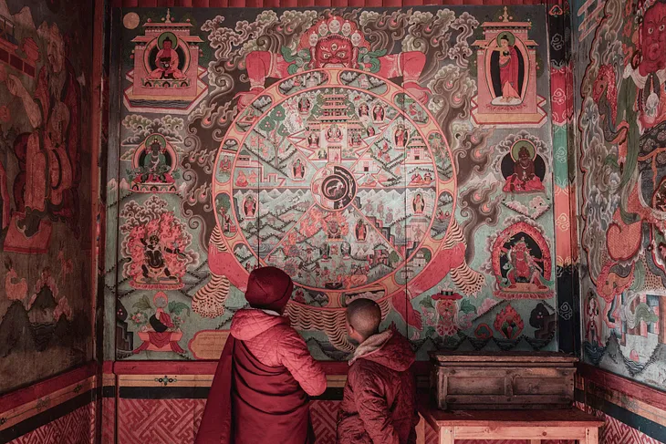 Buddhist novices in Nepal contemplating a fresco depicting samsara — the cycle of death and rebirth