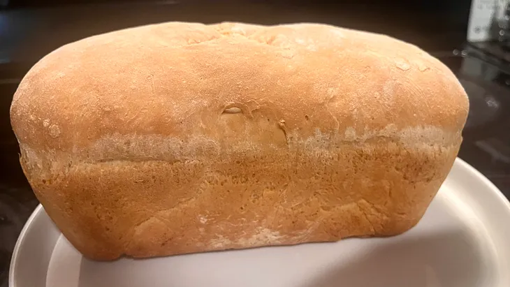 a loaf of homemade bread on a white plate.